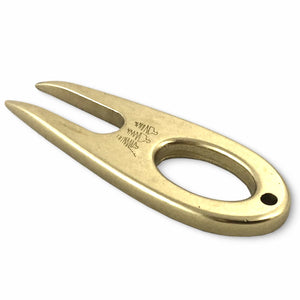 Golf divot tool solid brass showing side profile.